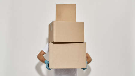 Picture of a young redhead deliveryman with three cardboard boxesの写真素材
