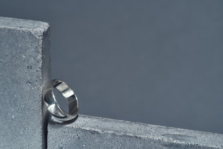 Closeup shot of silver ring on concrete element isolated over gray backgroundの写真素材