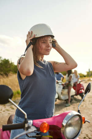 Smiling young caucasian girl putting on safety helmetの写真素材