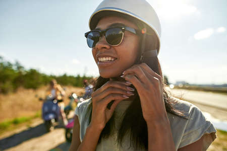 Portrait of happy african american girl putting on helmetの写真素材