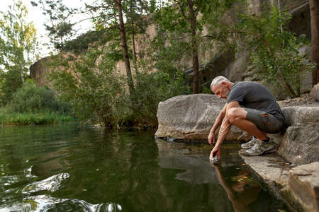 Middle aged caucasian man filling bottle with waterの写真素材