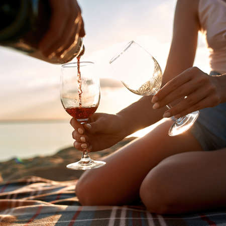 Young caucasian couple pouring red wine into glassesの写真素材