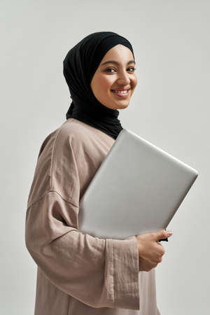 Cheerful young arabian woman with modern laptopの写真素材