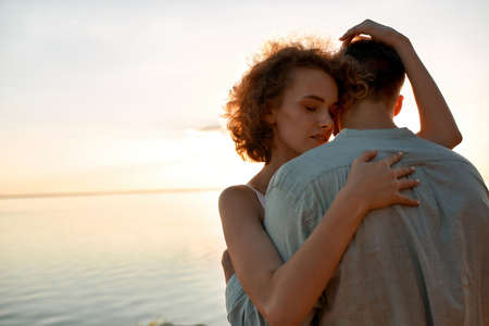 Portrait of tender young caucasian pair hugging at sunset