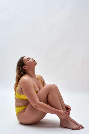 Attractive young plump caucasian woman with raised headの写真素材