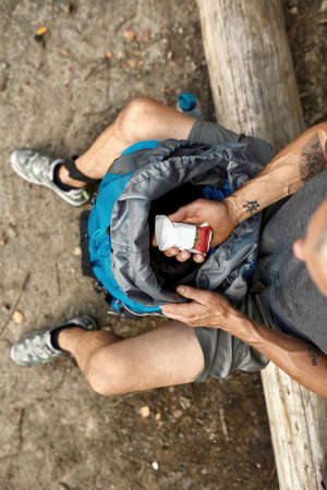 Top view of caucasian man taking out snack packの写真素材