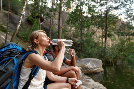 Young caucasian couple of tourists drinking waterの写真素材