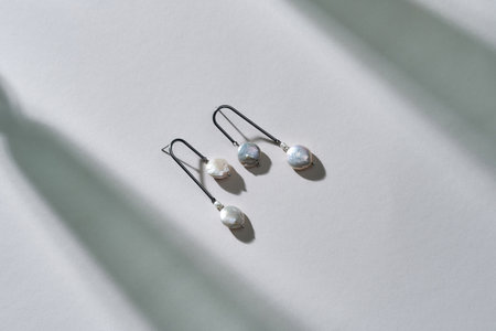 Studio shot of sterling silver dangle earrings with pearlsの写真素材