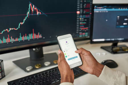 Close up man investor trade online using gadgets