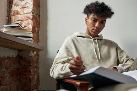Gen z teen male study distant reading book and taking notes