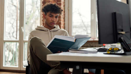 African American man read book work onlineの写真素材