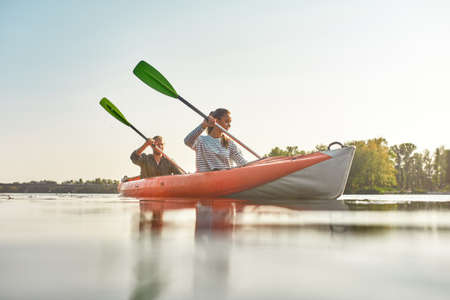 Young woman kayaking together with her boyfriend in a river on a summer dayの写真素材