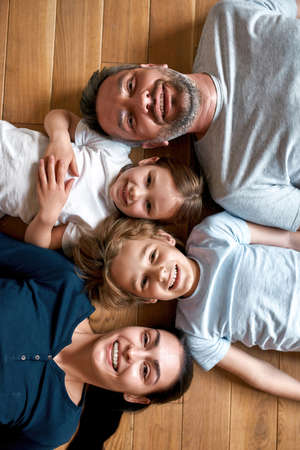 Portrait of smiling parents with kids lying on floorの写真素材