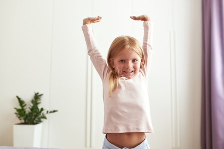 Portrait of smiling little girl do morning exerciseの写真素材