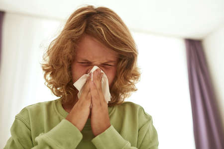 Unwell teen boy kid suffer from cold rest blow nose