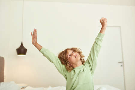 Teen boy child stretch wake up from sleepの写真素材