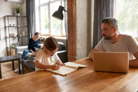 Caring father watch little daughter doing homework
