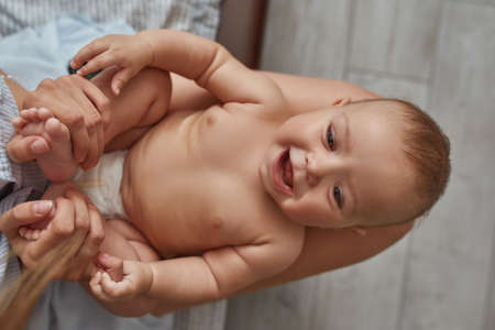 Pure emotions of joy, baby lying on kneesの写真素材