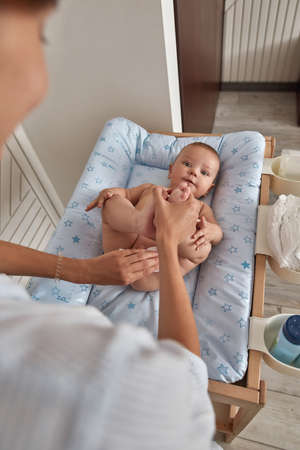 Caring mother gently cleansing and moisturizing babys soft skinの写真素材