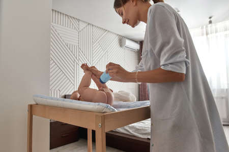 Mother using baby powder to keep babys skin dryの写真素材