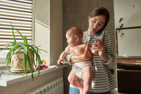 Portrait of young woman and cute little child in home interior