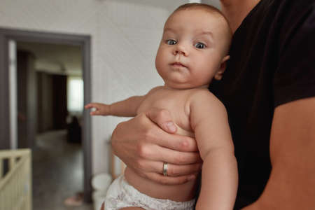 Funny surprised baby in strong mans armsの写真素材