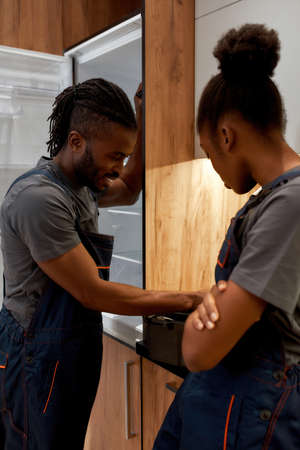 Fridge repair service cheerful worker with apprenticeの写真素材