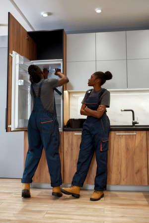 Female repairwoman giving advices to skilled handymanの写真素材