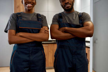 Couple of African manual workers in overalls, indoor portraitの写真素材