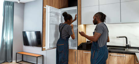 Competent handyman helping and advising unexperienced female apprenticeの写真素材