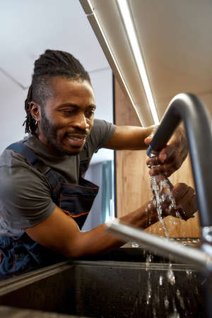 Plumber fixing high preasure kitchen tap leakの写真素材