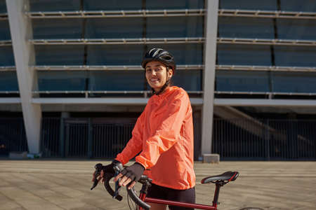 Portrait of smiling girl in sportswear ride bicycle outdoorsの写真素材