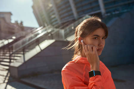 Millennial woman do sports outside wearing headphonesの写真素材