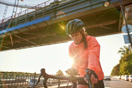 Active sporty woman ride bicycle use smartphone gadgetの写真素材