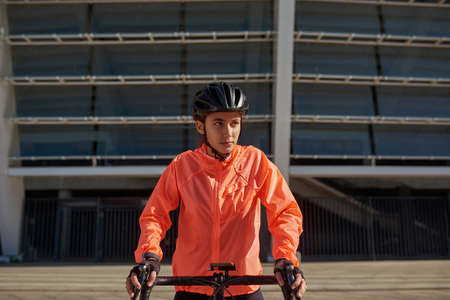 Active toned sportswoman in helmet ride bicycle outdoorsの写真素材