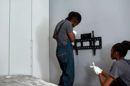 Tv hanger bracket installation on wall in bedroom
