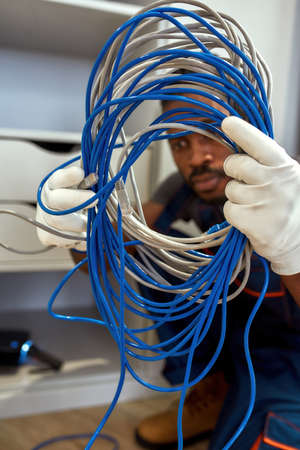 African American electrician with bunch of cables