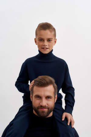 Portrait of small son sit on father backの写真素材