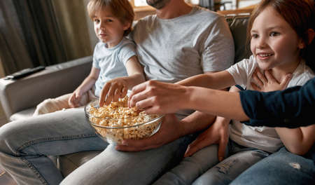 Happy kids relax with parents watching TVの写真素材