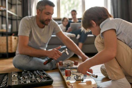 Caucasian father teach small on repairing with toolsの写真素材