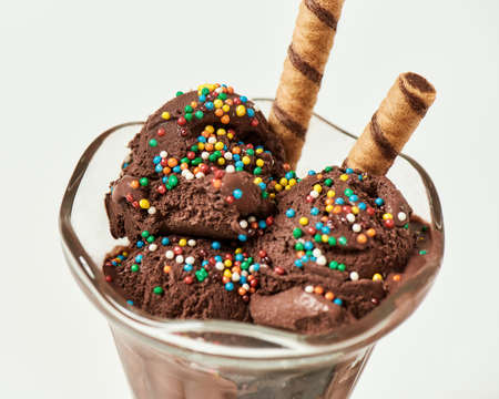 Close up of of tasty chocolate ice cream sprinkled with sweet grains and wafer sticks for dessert...