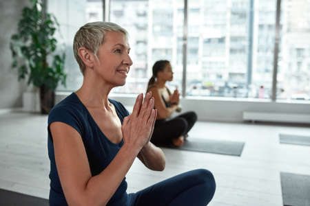 Active middle-aged woman meditate practice yoga on classの写真素材