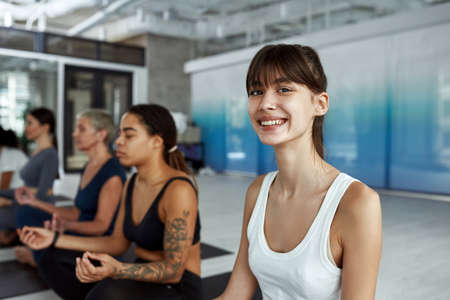 Happy millennial girl train practice yoga at group classの写真素材