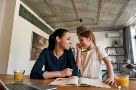 Smiling mother help daughter with homework assignmentの写真素材