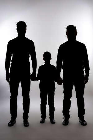 Shadows of three generations of men holding handsの写真素材