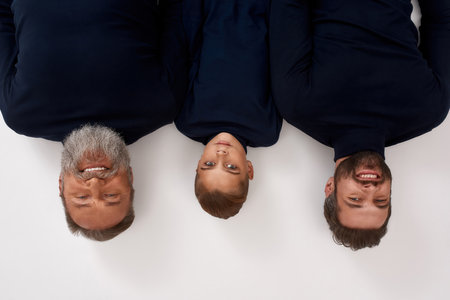 Upside down portrait of three generations of menの写真素材