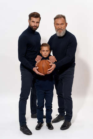 Portrait of sporty three generations of men with ball