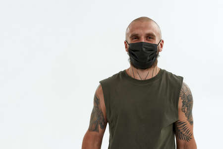 Young caucasian man in medical mask look at cameraの写真素材