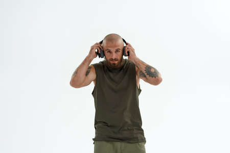 Caucasian man correcting earphones on his earsの写真素材