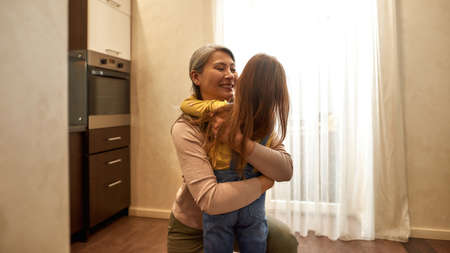 Emotional meeting. Happy grandmother embracing her cute granddaughter